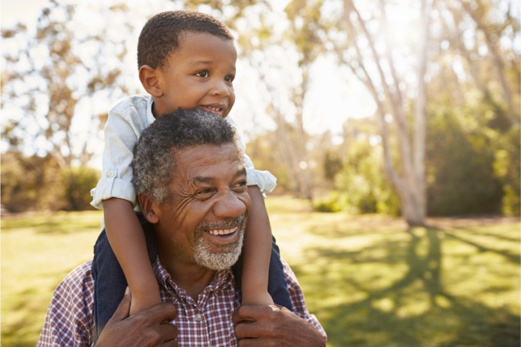 A picture of a happy man and child on his shoulder